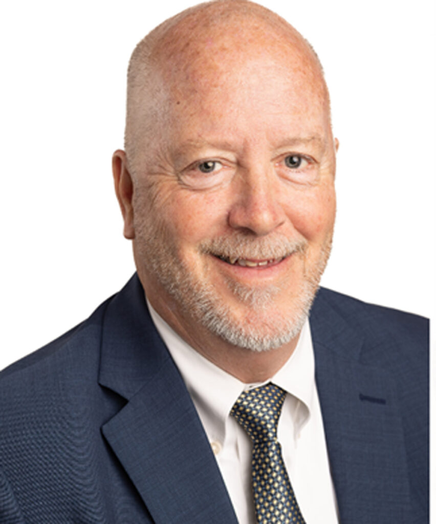 Gerry C. Schmelter, partner at Dillon, Miller, Ahuja, & Boss LLP, smiling in a professional suit, emphasizing expertise in real estate and business litigation.