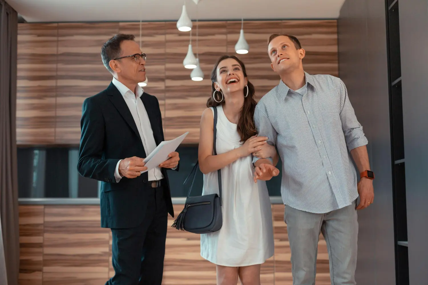 Real estate attorney guiding a couple during a property showing in a modern interior setting.