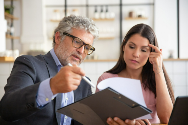 Real estate attorney consulting with a client, reviewing documents related to property title and legal guidance in a professional setting.