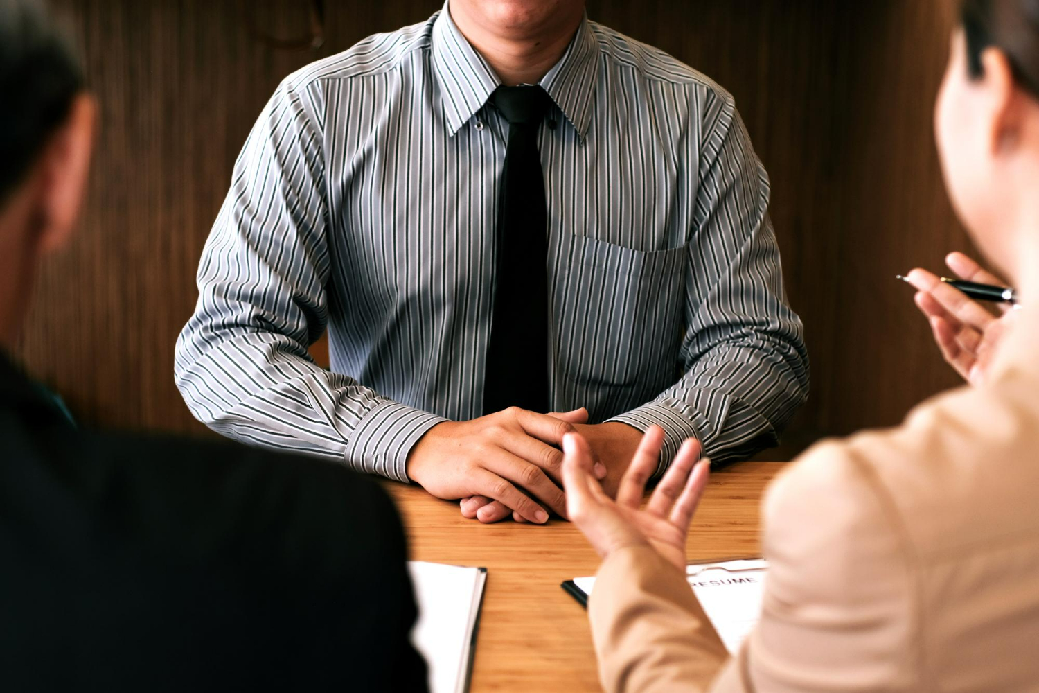 A professional discussion across a desk, symbolizing the formal and adversarial process often seen in real estate litigation