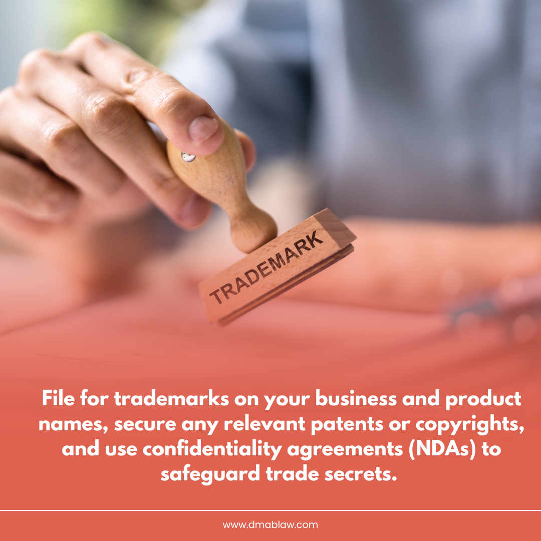 Hand holding a wooden stamp labeled "TRADEMARK" pressing down on a document, emphasizing the importance of trademark registration and legal protection for businesses.