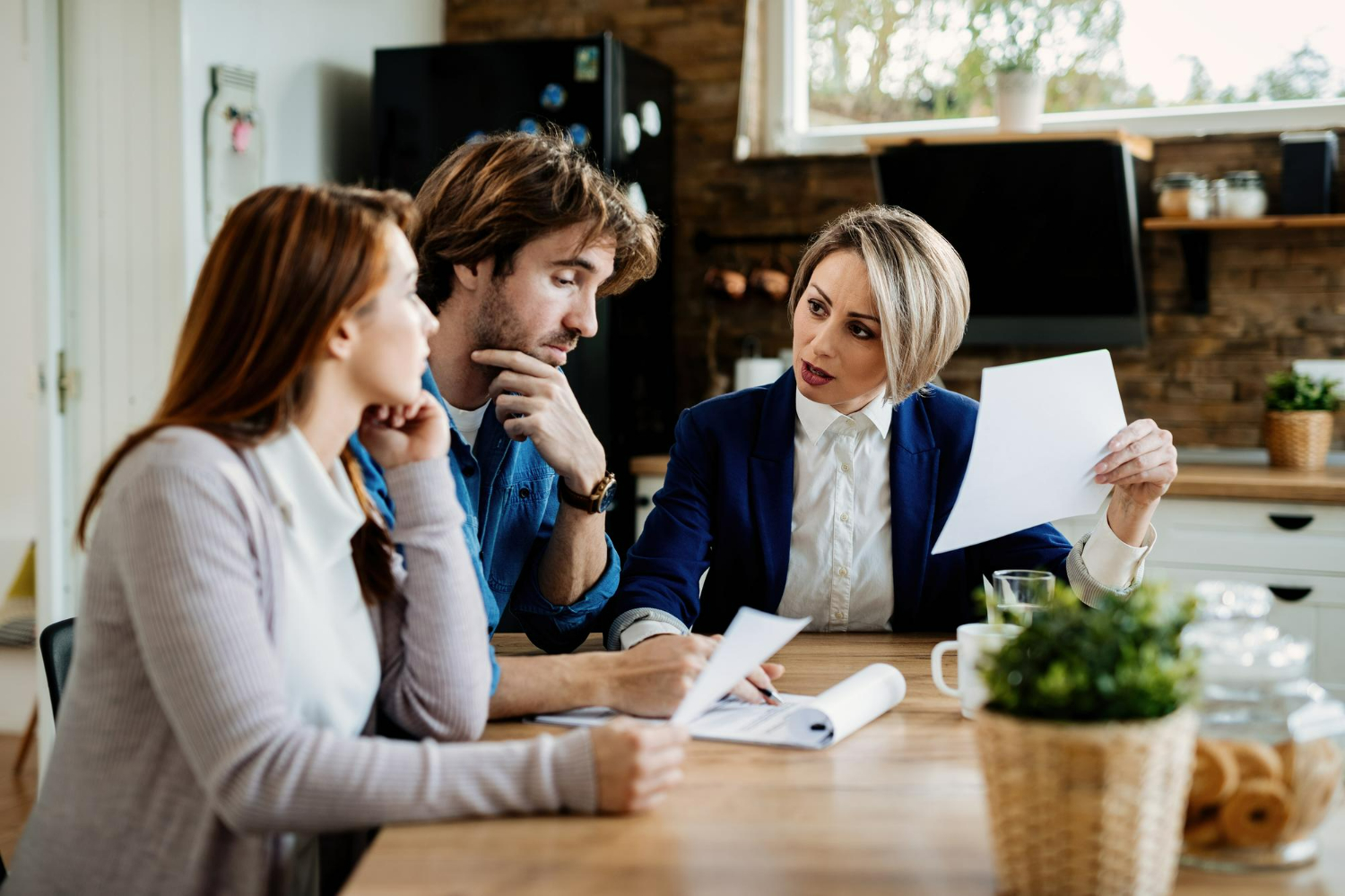 Real estate attorney consulting with clients in a modern office setting, discussing documents related to property transactions.
