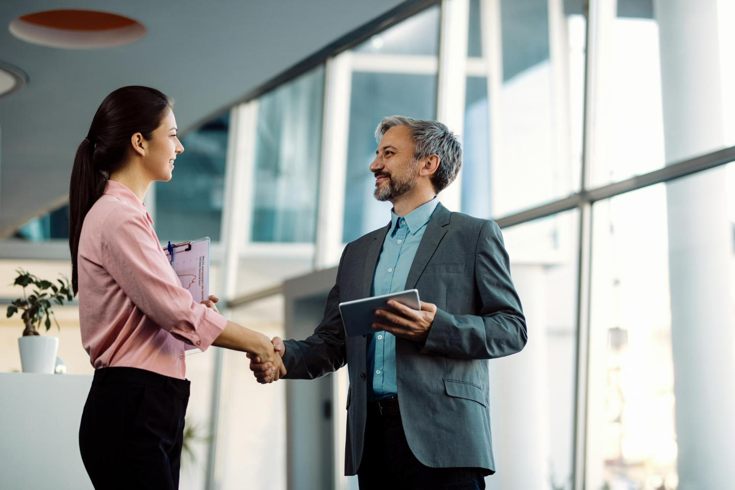 Business partners finalizing an agreement with a handshake in a modern office setting
