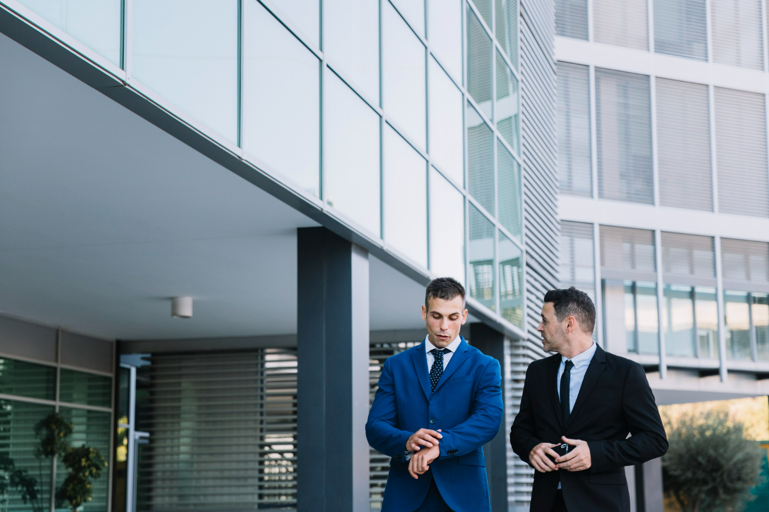 Commercial real estate professionals discussing a property transaction outside a modern office building in California