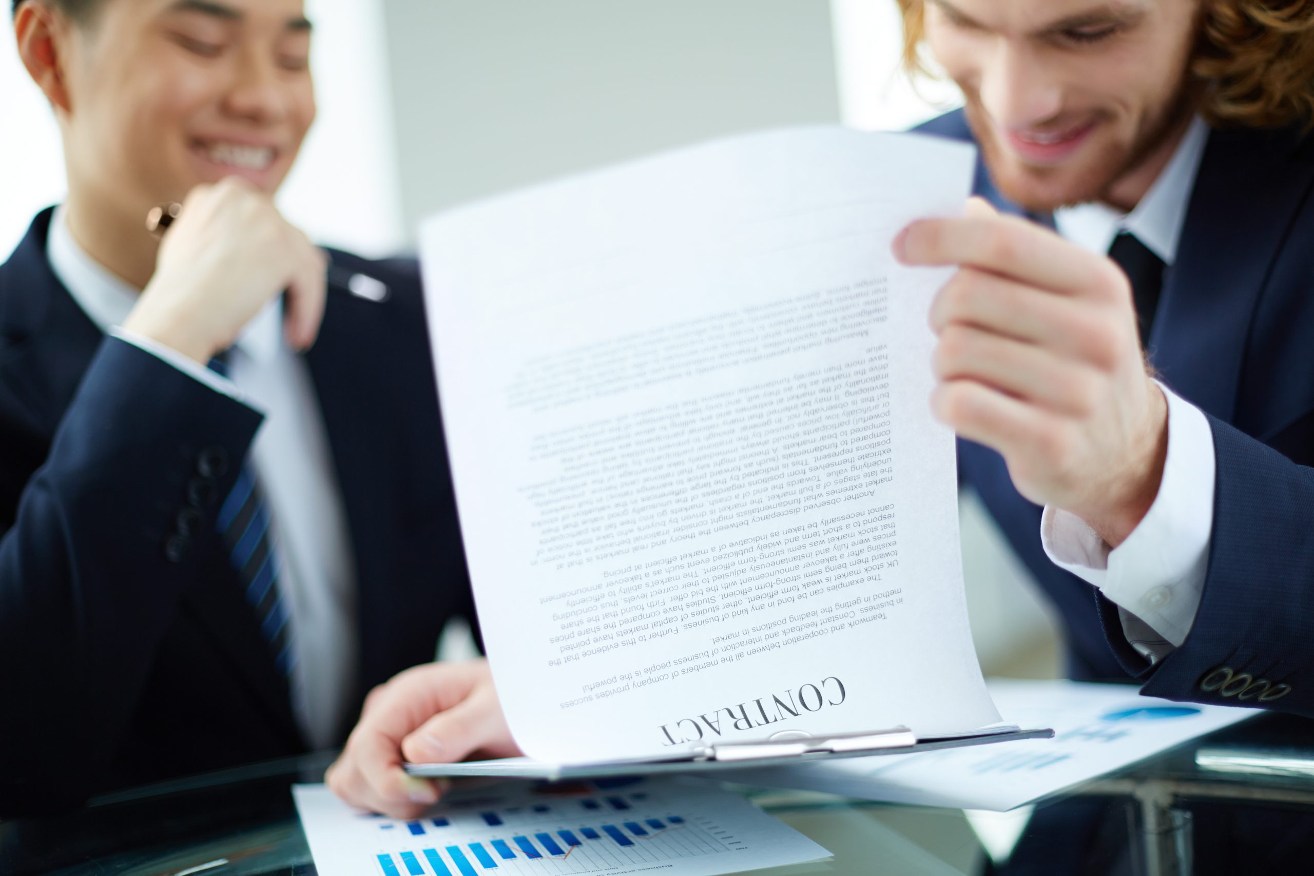Business professional holding a folder while standing outside a modern office building, representing legal or business services