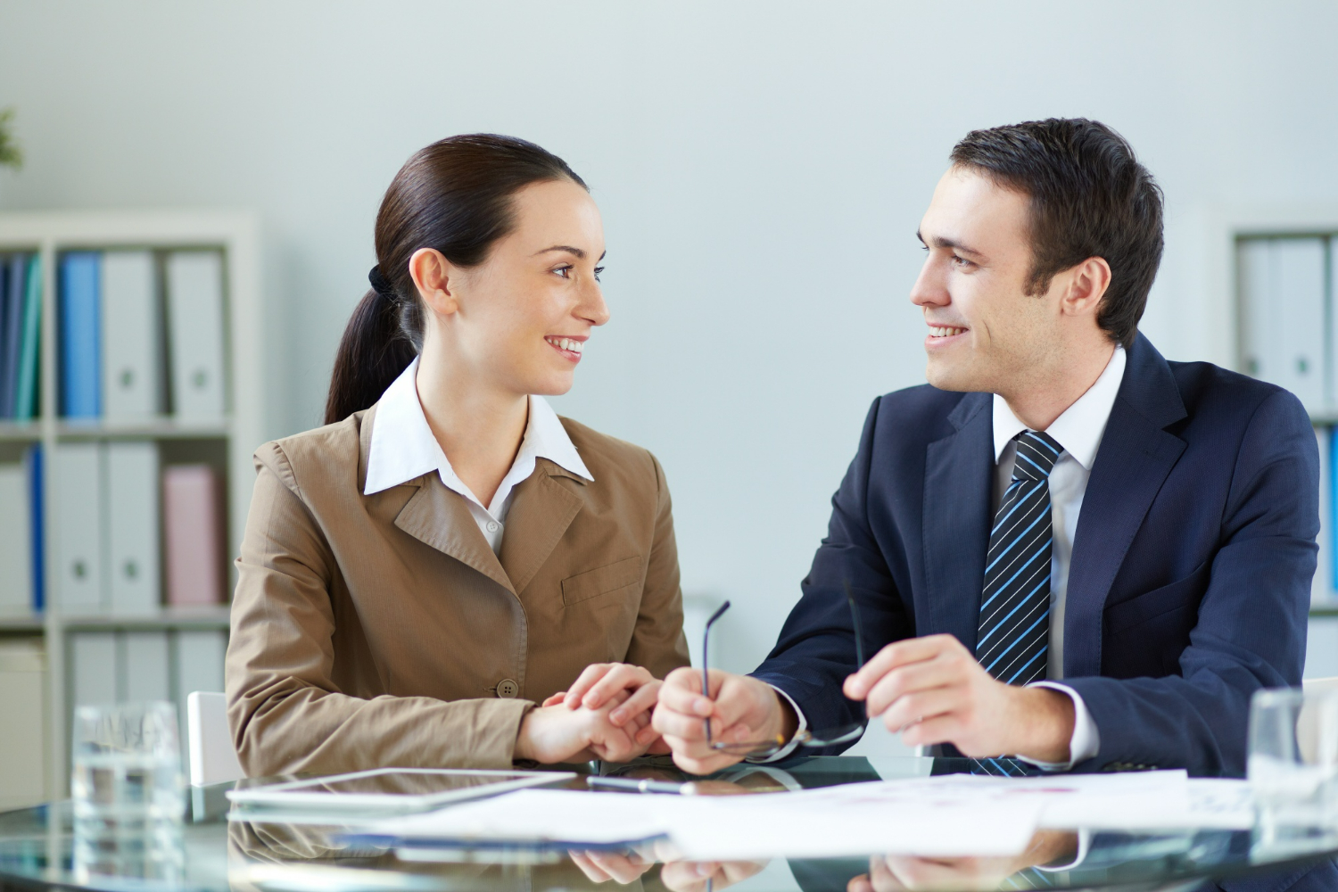 Business attorney and client seated at a conference table reviewing documents together, illustrating when to involve legal counsel in a business transaction