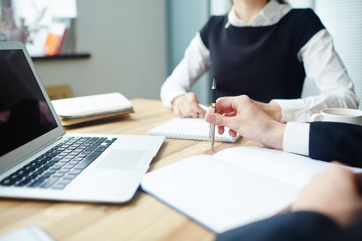 Close-up of a lease agreement review with laptop and notes during a business meeting