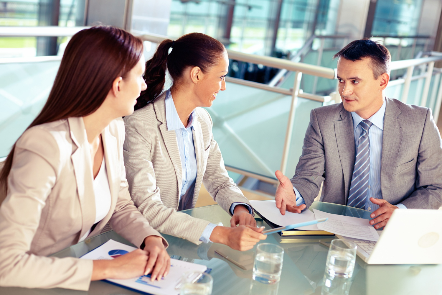 Business professionals and a business attorney discussing strategy and reviewing documents during a meeting