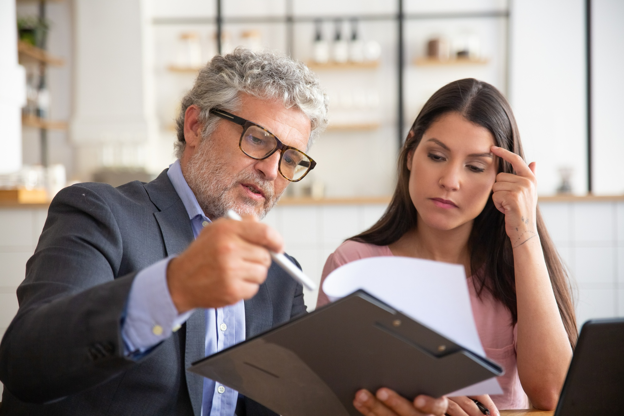 Real estate attorney reviewing purchase agreement documents with a concerned buyer